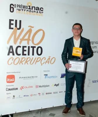 With the trophy and the certificate, at the ceremony's official backdrop.
